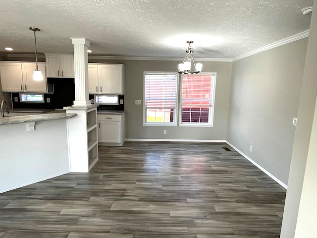 kitchen featuring white cabinetry, crown molding, an inviting chandelier, and dark wood-style flooring