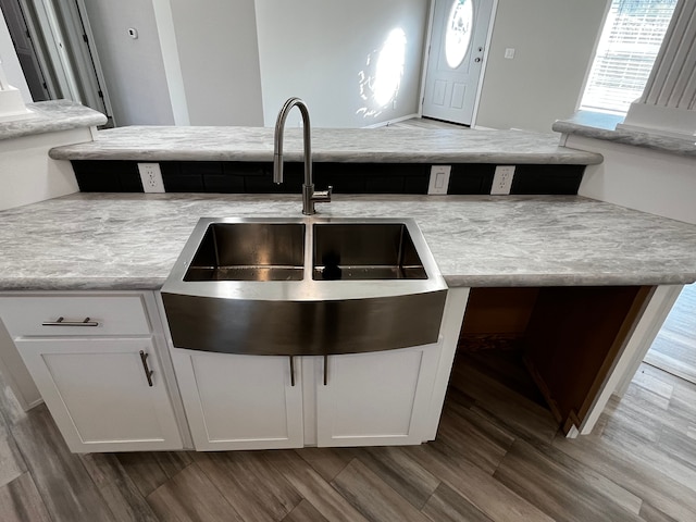 kitchen featuring a sink, dark wood-style flooring, light countertops, and white cabinetry