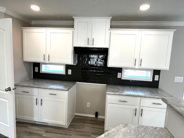 kitchen with tasteful backsplash, ornamental molding, recessed lighting, wood finished floors, and white cabinets