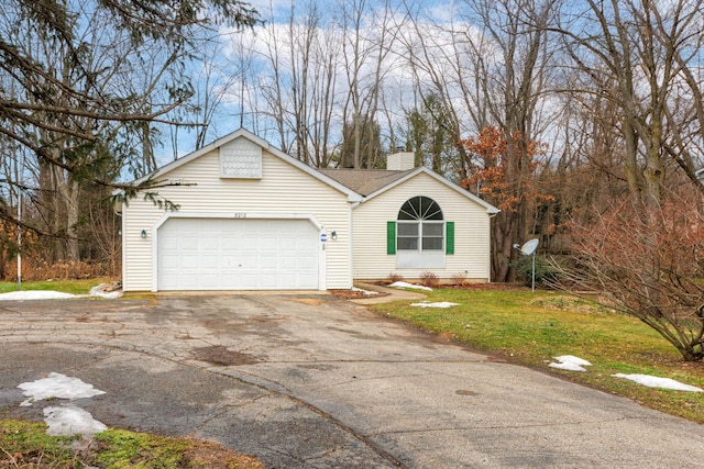 view of front of house with driveway, an attached garage, and a chimney