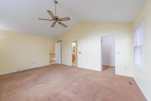 unfurnished bedroom with light carpet, baseboards, visible vents, a spacious closet, and vaulted ceiling