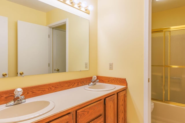 full bath featuring enclosed tub / shower combo, a sink, toilet, and double vanity