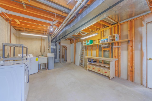 unfinished basement with a sink and washing machine and clothes dryer