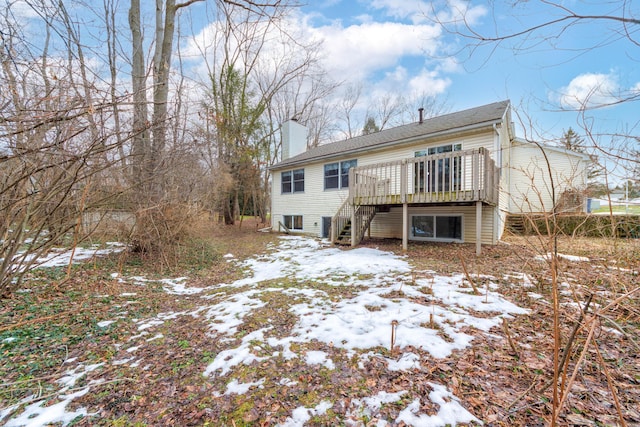 snow covered house featuring stairs, a chimney, cooling unit, and a wooden deck