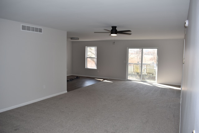 empty room with baseboards, carpet, visible vents, and a ceiling fan