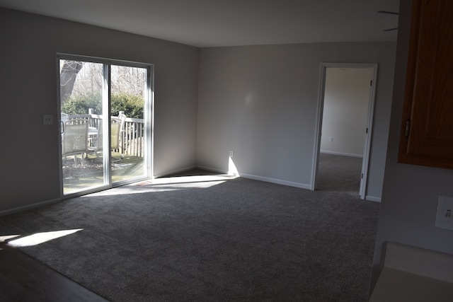 carpeted empty room featuring baseboards