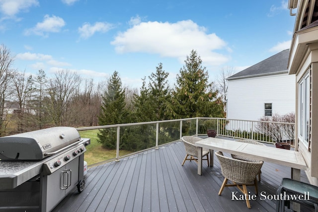 deck featuring outdoor dining area and a grill