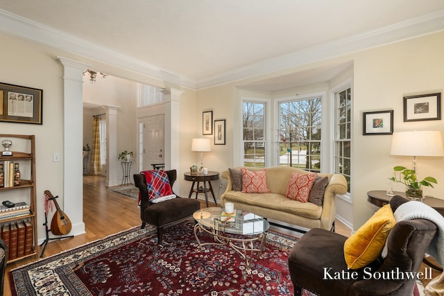 living room with ornamental molding, wood finished floors, decorative columns, and baseboards