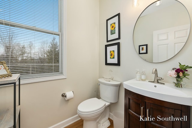 bathroom featuring toilet, baseboards, and vanity