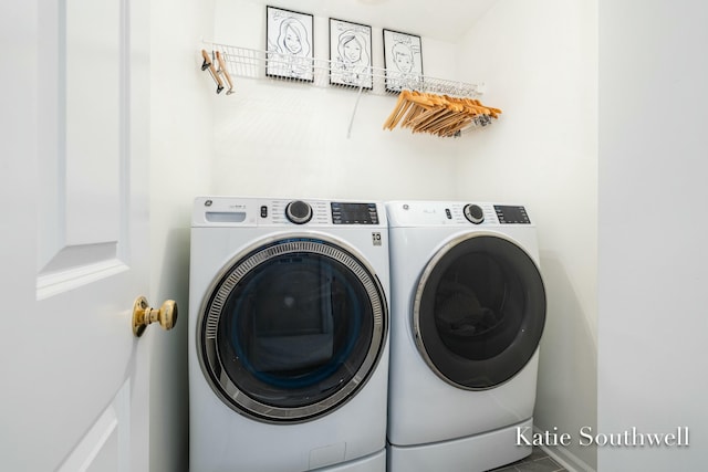 washroom with laundry area, washer and clothes dryer, and baseboards