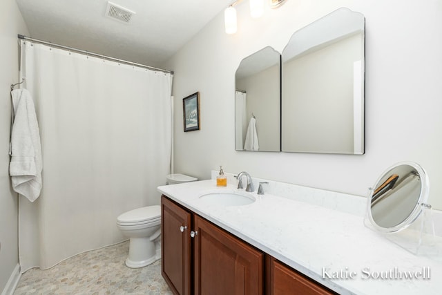 bathroom featuring visible vents, vanity, and toilet