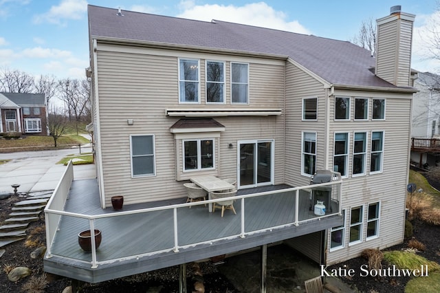 back of property featuring a deck and a chimney