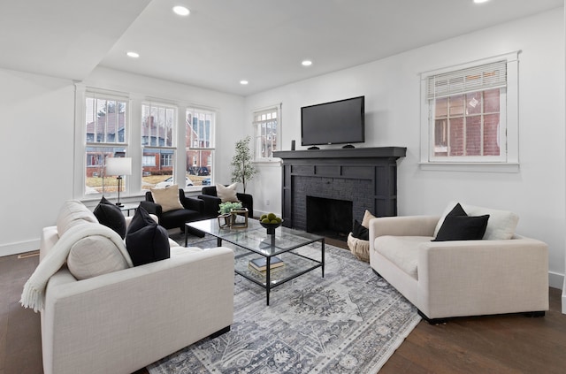 living area featuring recessed lighting, a fireplace, baseboards, and wood finished floors