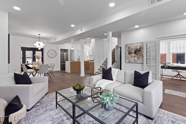 living area with visible vents, baseboards, stairway, a chandelier, and recessed lighting