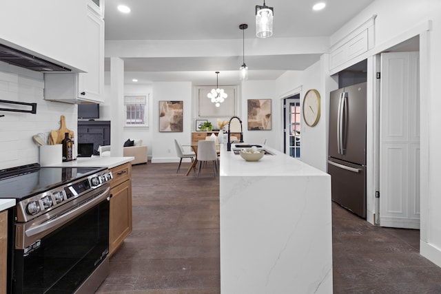 kitchen featuring stainless steel appliances, dark wood-type flooring, a sink, and decorative backsplash