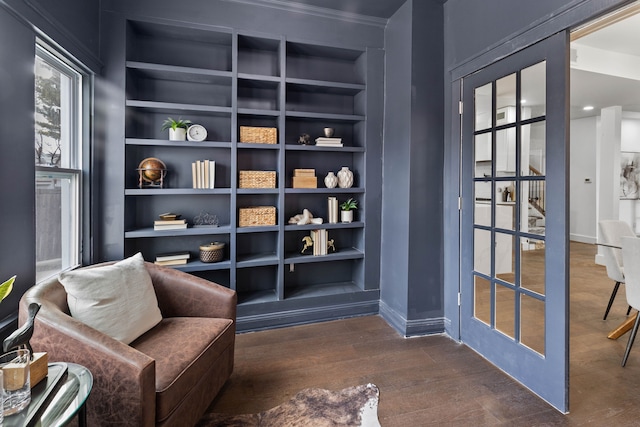 living area featuring dark wood-type flooring, built in features, and baseboards