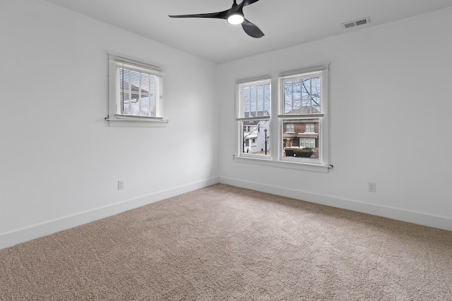 unfurnished room featuring a ceiling fan, carpet, visible vents, and baseboards