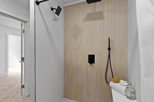 bathroom with a tile shower and crown molding