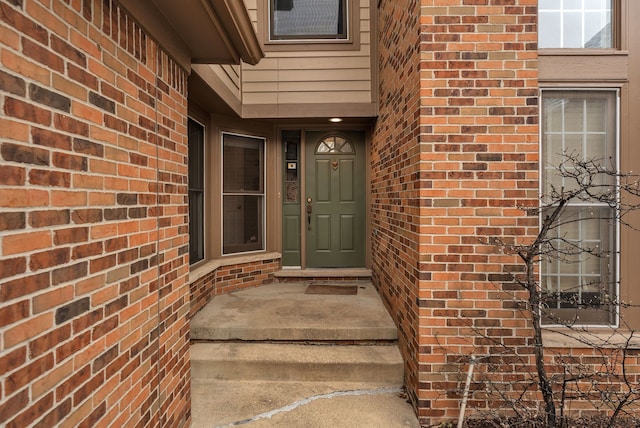 view of exterior entry with brick siding