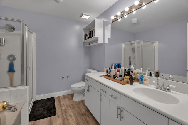 full bath with baseboards, toilet, wood finished floors, vanity, and a shower stall