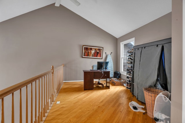 office space featuring high vaulted ceiling, light wood-type flooring, and baseboards