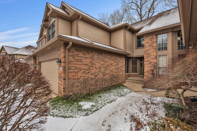 view of property exterior with a garage and brick siding