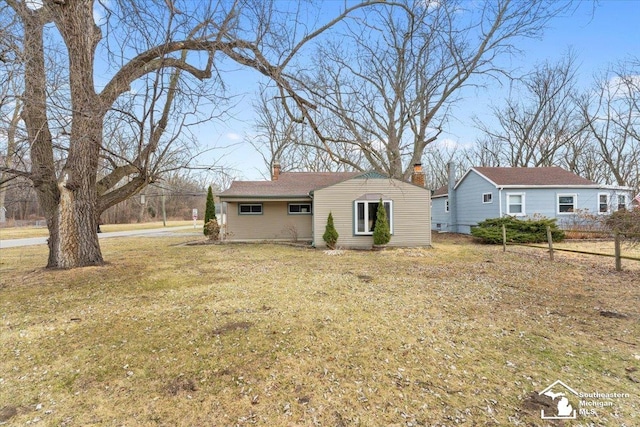 view of front facade with a chimney and a front yard