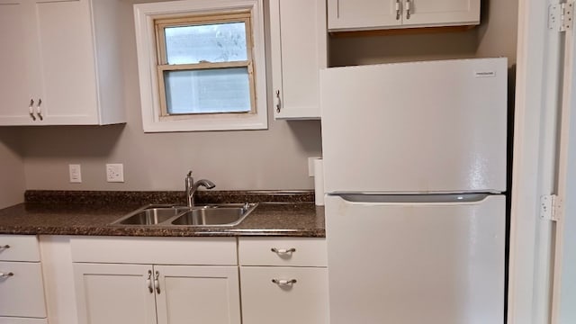 kitchen with a sink, white cabinetry, and freestanding refrigerator