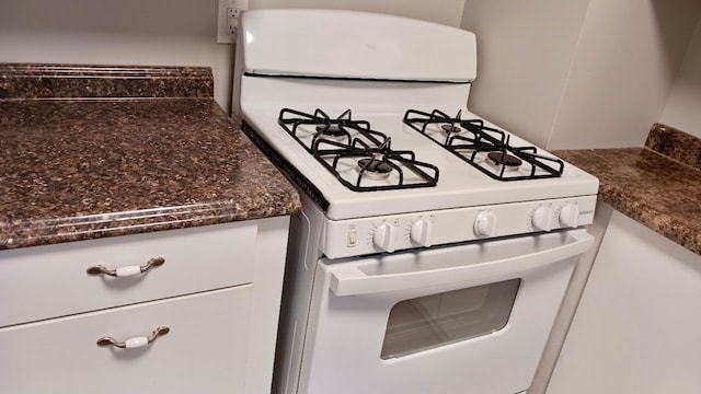 room details with white cabinetry and white gas range