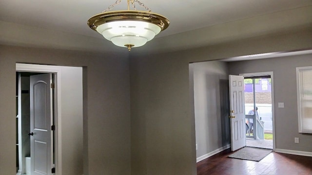 entryway with dark wood-style floors and baseboards