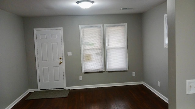 entryway with dark wood-style floors, visible vents, and baseboards