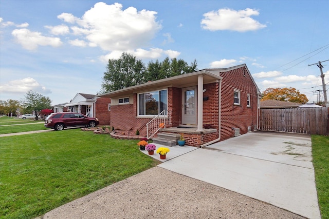 view of front of home featuring a front yard, fence, and brick siding