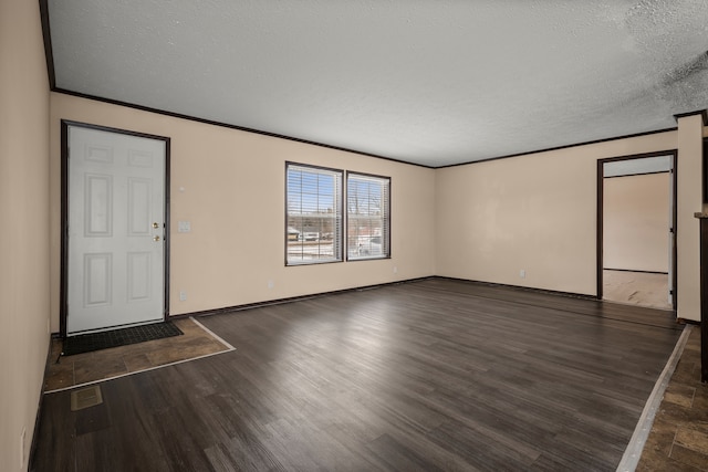 foyer entrance featuring crown molding, a textured ceiling, baseboards, and wood finished floors