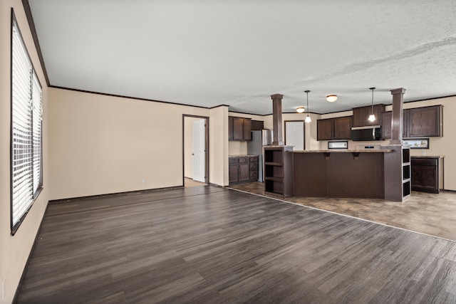 interior space featuring dark wood-type flooring, crown molding, a textured ceiling, and decorative columns