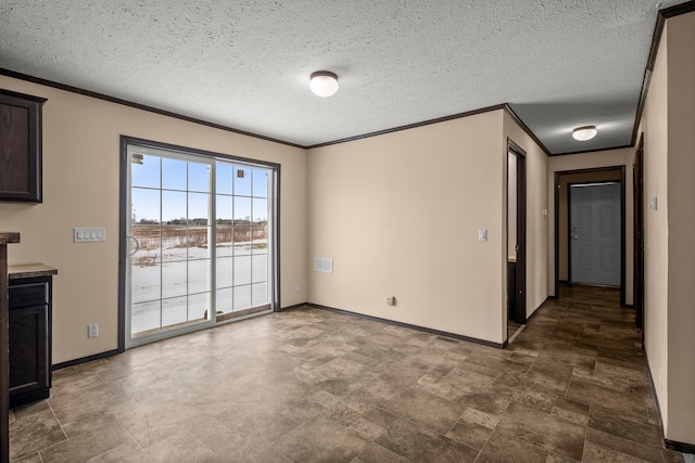 unfurnished room with a textured ceiling, baseboards, and crown molding