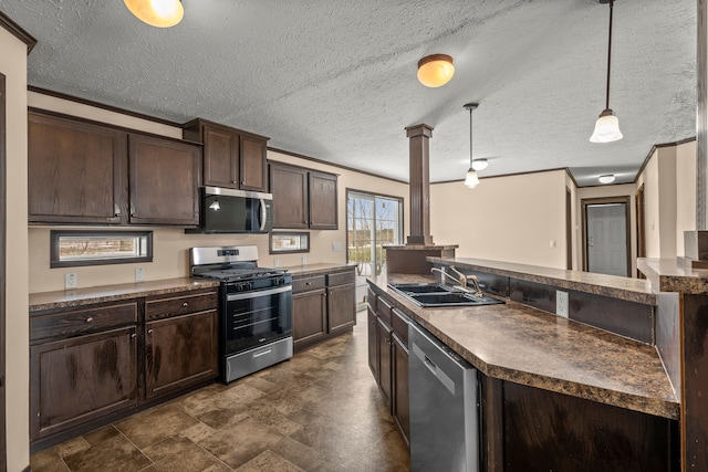 kitchen with a sink, dark brown cabinets, appliances with stainless steel finishes, dark countertops, and pendant lighting