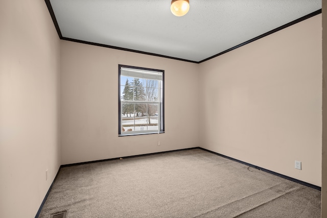 carpeted empty room featuring visible vents, a textured ceiling, baseboards, and crown molding