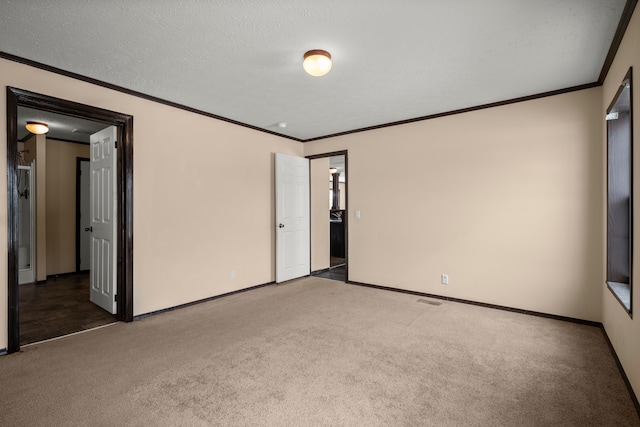 carpeted empty room featuring baseboards, visible vents, ornamental molding, and a textured ceiling