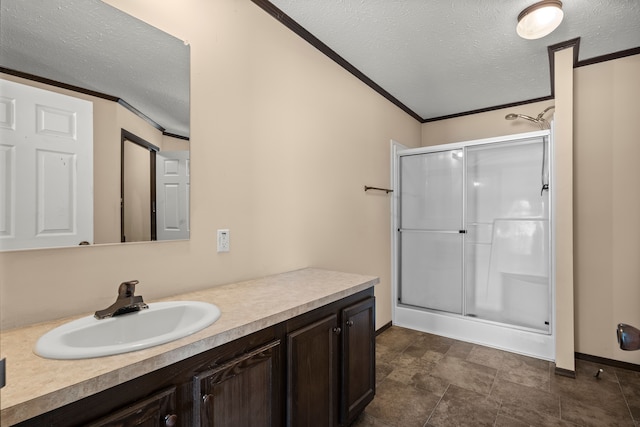 bathroom with a textured ceiling, a stall shower, and vanity