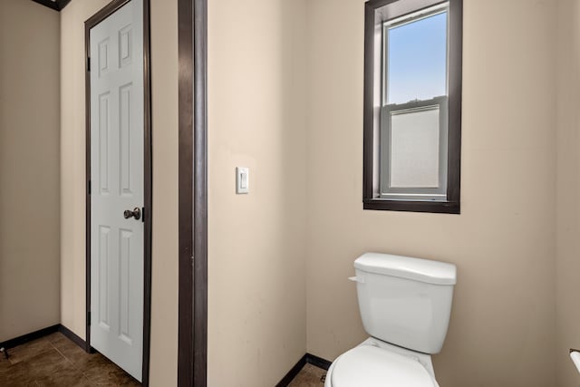 bathroom with toilet and baseboards