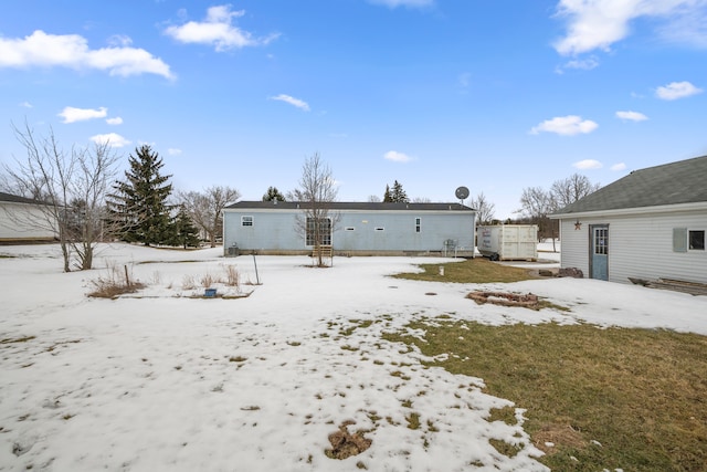 view of snow covered back of property