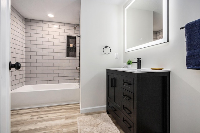 bathroom featuring wood finished floors, recessed lighting, vanity, baseboards, and shower / bathtub combination