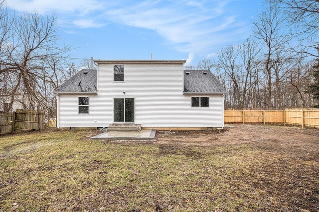 rear view of property with fence, a shingled roof, a lawn, and entry steps