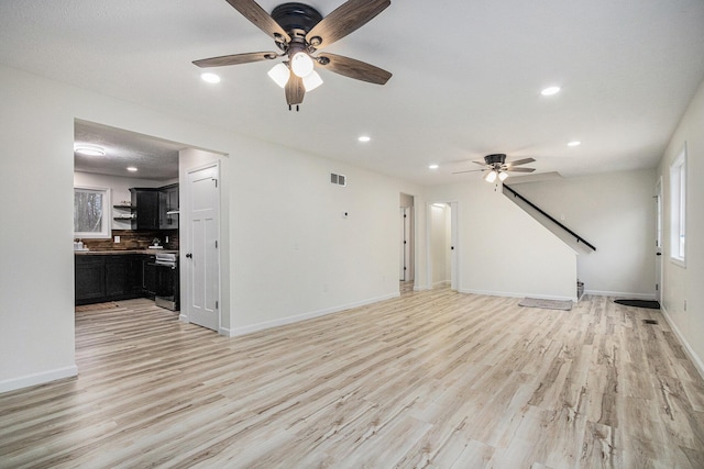 unfurnished living room with recessed lighting, baseboards, visible vents, and light wood finished floors