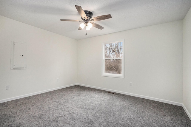 carpeted empty room featuring electric panel, a ceiling fan, baseboards, and a textured ceiling