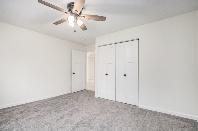 unfurnished bedroom with a closet, baseboards, ceiling fan, and carpet flooring