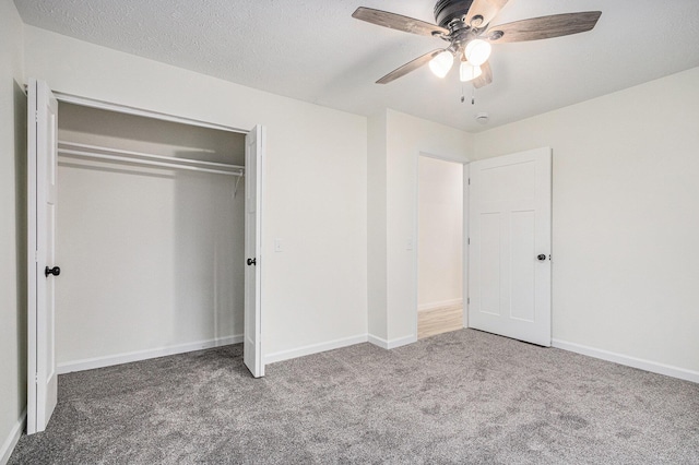 unfurnished bedroom featuring a closet, carpet floors, a textured ceiling, and baseboards