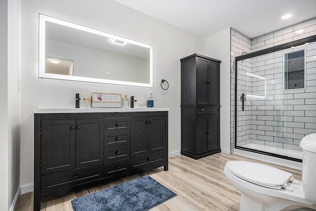 bathroom with wood finished floors, visible vents, double vanity, a stall shower, and toilet