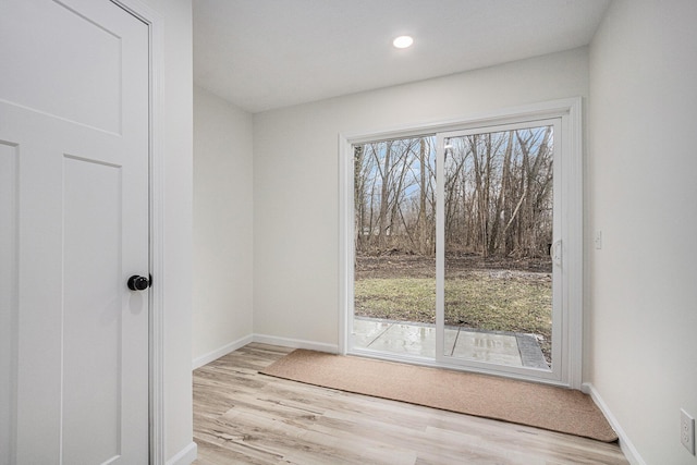 unfurnished room with plenty of natural light, baseboards, and wood finished floors