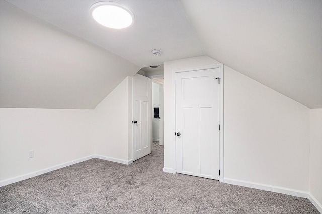 bonus room featuring lofted ceiling, carpet flooring, and baseboards